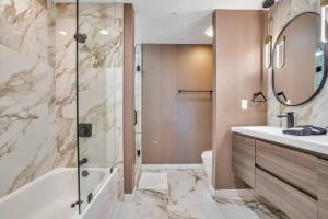 une salle de bain avec une baignoire, un lavabo et un miroir dans l'établissement 3 bedroom Corner Suite, à Orlando 37 autres photos