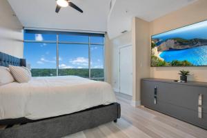 sypialnia z dużym łóżkiem i dużym oknem w obiekcie Lake Eola Corner 3 BDRM Suite w Orlando