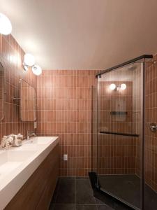a bathroom with a shower and a sink and a mirror at Madeira Cottage - Amphitheater in Saint Augustine