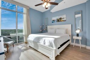 a bedroom with a white bed and a ceiling fan at 2 Bdrm Penthouse with Billiards in Orlando