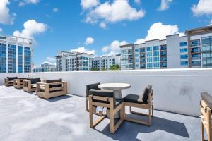 a balcony with chairs and a table and buildings at 2 Bdrm Penthouse with Billiards in Orlando