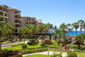 - Vistas a un complejo con palmeras y parque infantil en Beachfront Premium Ocean View 5 Star Beach View, en Cabo San Lucas