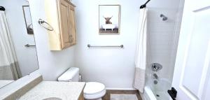 a white bathroom with a toilet and a sink at Paddleboards, Grill, Fire Pit, Air Hockey, WD, Brkfst, Sleeps 14 in Page +18 photos