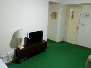 a room with a television and a green carpet at Dpto del Centro in Rosario