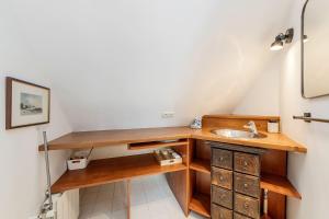 a bathroom with a sink and wooden cabinets at ATLAS beautiful 2-Bed Apartment near the Sea in Saint Malo