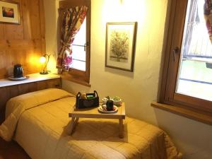 Un dormitorio con una cama con una mesa. en Maison Colombot, en Aosta