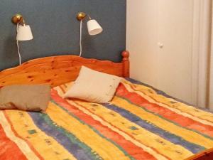 a bed with a colorful blanket and two pillows on it at 4 star holiday home in Ljungskile in Ljungskile