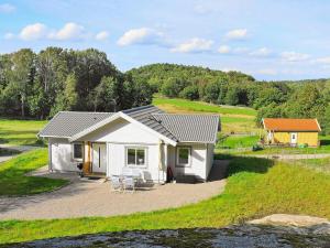 a small white house with a table and chairs at 4 star holiday home in Ljungskile in Ljungskile