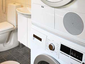 a washing machine in a bathroom with a toilet at 4 star holiday home in Ljungskile in Ljungskile +14 photos