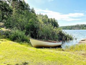 a small boat sitting on the shore of a lake at 8 person holiday home in Valdemarsvik in Valdemarsvik