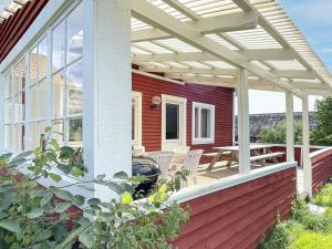 a pergola on a house with a table and chairs at 8 person holiday home in Valdemarsvik in Valdemarsvik