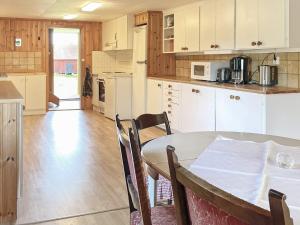 a kitchen with a table and a table and chairs at 8 person holiday home in VALDEMARSVIK in Valdemarsvik +16 photos