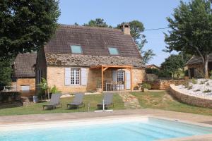una casa con una piscina di fronte di Les Mazaux avec piscine chauffée au nord de Sarlat a La Chapelle-Aubareil