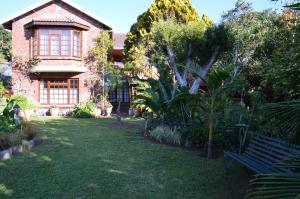 a house with a bench in front of a yard at Cosy Cottage in Sedgefield