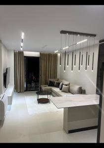 a living room with a couch and a chandelier at Sweet HOME in Shëngjin