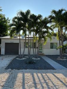 a house with palm trees in front of it at Mid-Century with Outdoor Oasis in Fort Lauderdale