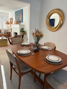 a wooden dining room table with chairs and a mirror at Mid-Century with Outdoor Oasis in Fort Lauderdale