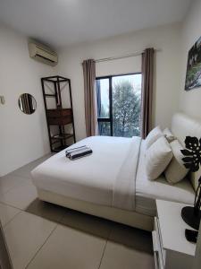 a large white bed in a room with a window at Swiss Garden resort residence by Moonlight in Kuantan
