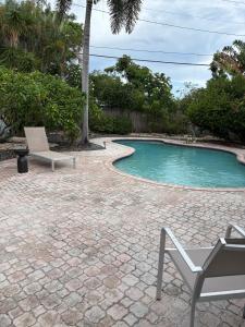 a patio with a chair and a swimming pool at Mid-Century with Outdoor Oasis in Fort Lauderdale