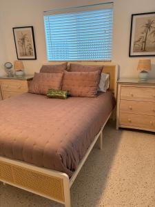 a bed in a bedroom with two dressers and a window at Mid-Century with Outdoor Oasis in Fort Lauderdale +22 photos