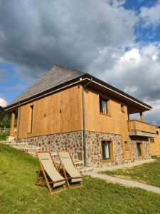 マグラにあるVatra Chaletの建物前の芝生に座る椅子2脚