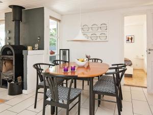 a kitchen and dining room with a wooden table and chairs at Seaside Haven with Swing - By Traum Ferienwohnungen in Glesborg