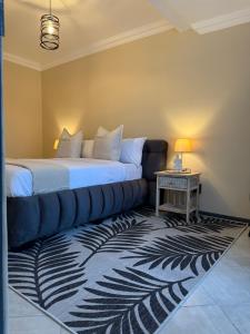 a bedroom with a bed and a couch and a table at Hamisi Manor Guest House in Midrand +52 photos