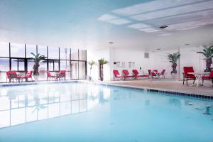 a large swimming pool with red chairs and tables at Rainbow Hotel Casino by Peppermill Resorts in West Wendover