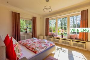 a bedroom with a bed in a room with windows at Luxury Villa EMG Steinfurt Münster Enschede - Steinfurt in Steinfurt