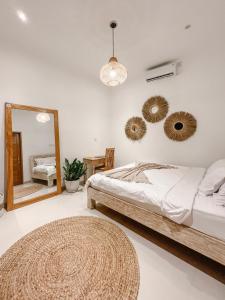 a bedroom with a bed and a mirror at Villa Obo Pererenan by REJA Villas in Munggu