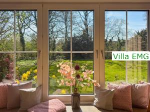 a vase of flowers in a room with windows at Luxury Villa EMG Steinfurt Münster Enschede - Steinfurt in Steinfurt