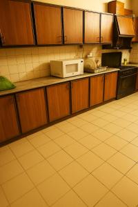 Una cocina con gabinetes de madera y microondas. en Secure Central Room Diplomatic Enclave, Islamabad, en Islamabad 5 fotos más