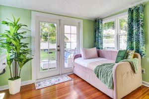 ein Wohnzimmer mit grünen Wänden und einem rosa Sofa in der Unterkunft St Pete Home for Retreat and Corporate Travelers in St Petersburg