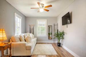 a living room with a white couch and a ceiling fan at Modern Private Tampa Getaway Steps from Ybor in Tampa