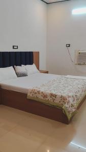 Un dormitorio con una cama grande con una manta encima. en Ramansh Home stay, en Ayodhya
