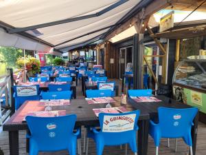 una fila di tavoli e sedie su un patio di Mobil-home 2 chambres côté rivière a Ébreuil