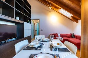 a dining room with a table and chairs and a couch at Casa Peku in Monza