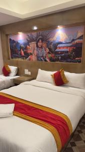 two beds in a hotel room with a painting on the wall at Hotel JS Pashupati in Kathmandu