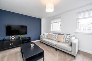 a living room with a couch and a tv at The Gordon Vacant Nests Heart Of Aberdeen in Aberdeen
