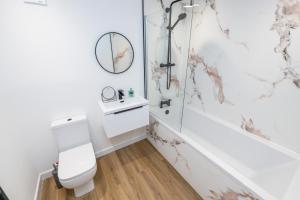 a white bathroom with a toilet and a shower at The Gordon Vacant Nests Heart Of Aberdeen in Aberdeen +18 photos