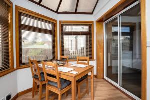 a dining room with a table and chairs and windows at 110 Wardlaw Retreat-wifi-parking in Oakley