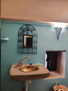 a bathroom with a sink and a mirror at Riad Menthe Et Citron in Meknès