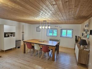 a dining room with a wooden table and chairs at L'Ancienne Scierie in Ban-sur-Meurthe-Clefcy