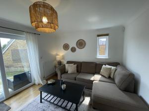 una sala de estar con un sofá y una mesa en Greenfields House Ashford, en Kent