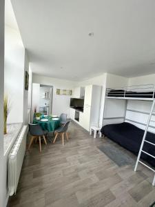 a living room with a bed and a table and chairs at Lumineux et rénové studio en centre ville in Givet