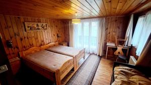 Un dormitorio con una cama en una habitación de madera. en FREE Bus Winter Haus Ramona, en Saas-Grund