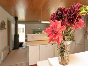a vase filled with red flowers sitting on a table at Tranquil Retreat with Spa - By Traum Ferienwohnungen in Ho +39 photos