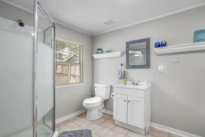 a bathroom with a toilet and a sink and a shower at 3 Bedroom Gulfport Rental by Next Step Property Management in Gulfport +13 photos