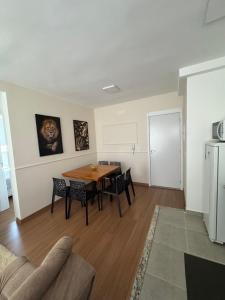 a living room with a table and chairs and a refrigerator at Apartamento em Barretos in Barretos