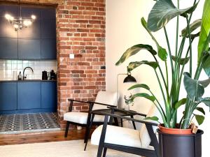 a living room with a table and a plant at Jagiellończyka Apartment - Self Check-In 20h in Wrocław
